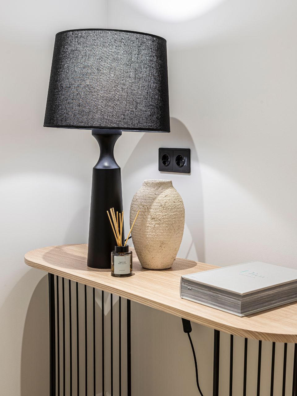Lámpara de mesa con base de madera y pantalla tela negra.