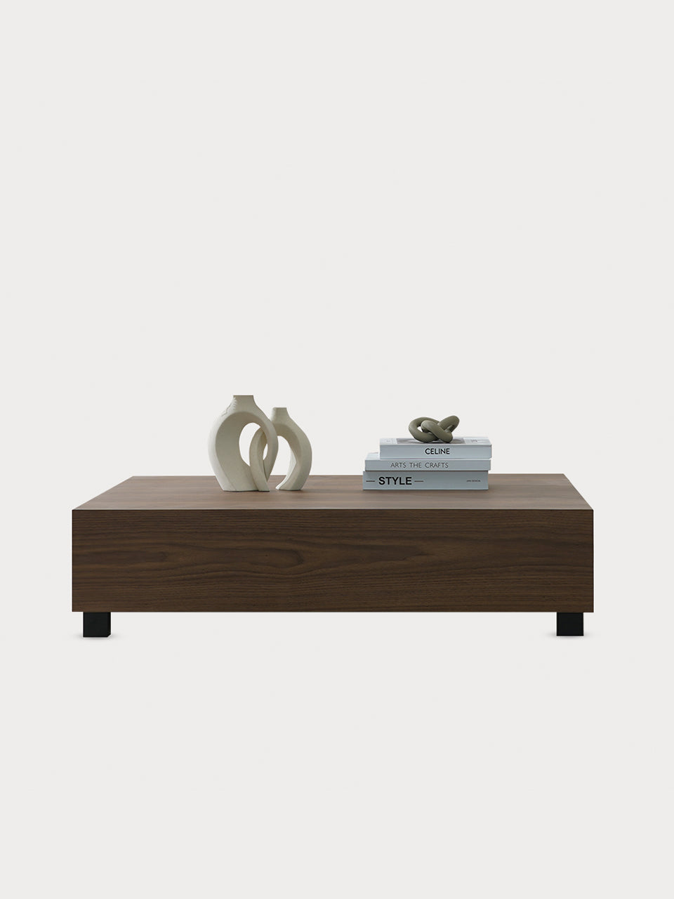 Mesa de centro cuadrada en madera de nogal con decoración sobre ella en vista frontal.