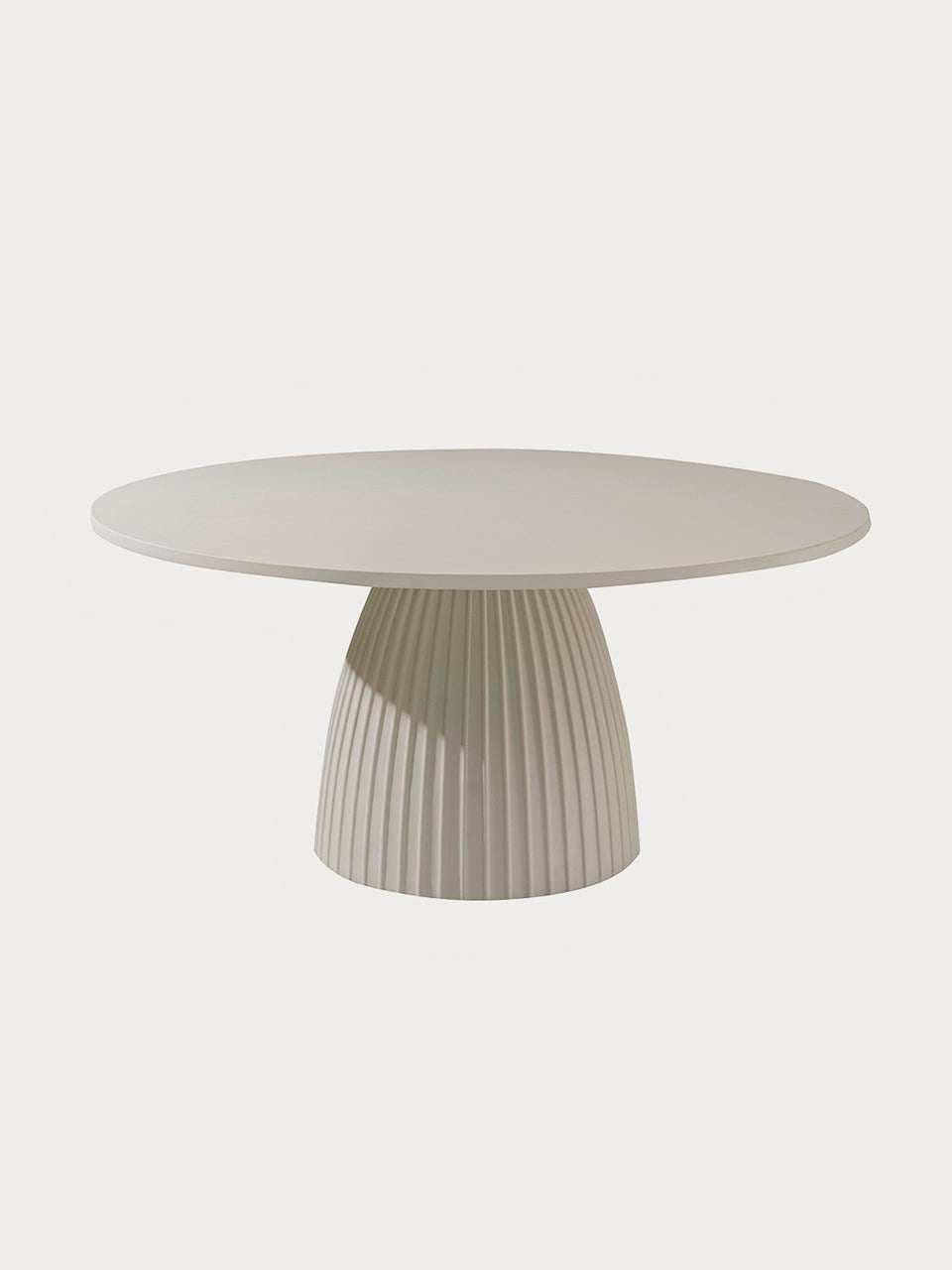 Mesa de comedor de microcemento circular con pie acanalado en vista frontal.