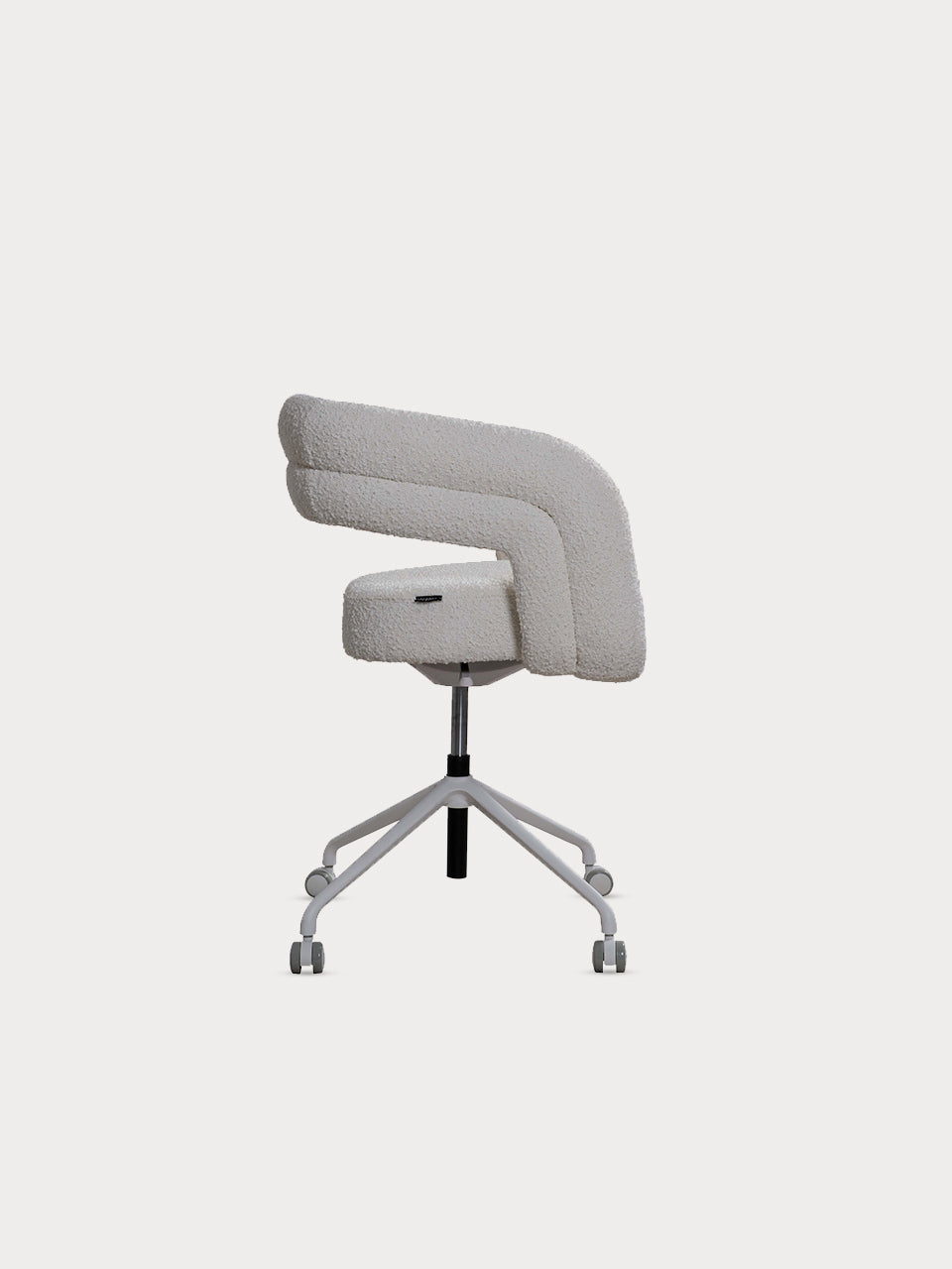 Silla de escritorio en tejido bouclé color blanco y patas metalizadas en vista lateral.