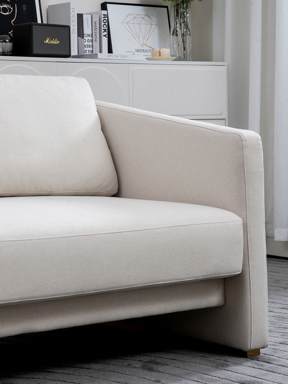 Detalle de sofá cama de 3 plazas abierto en tejido beige.