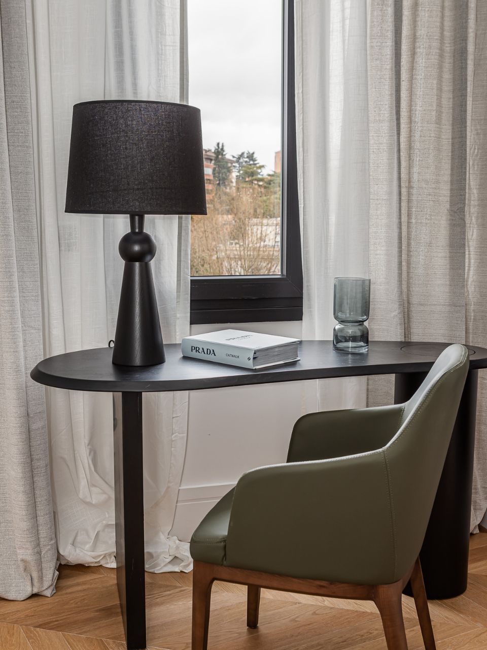 Lámpara de mesa negra de madera y pantalla de tela.