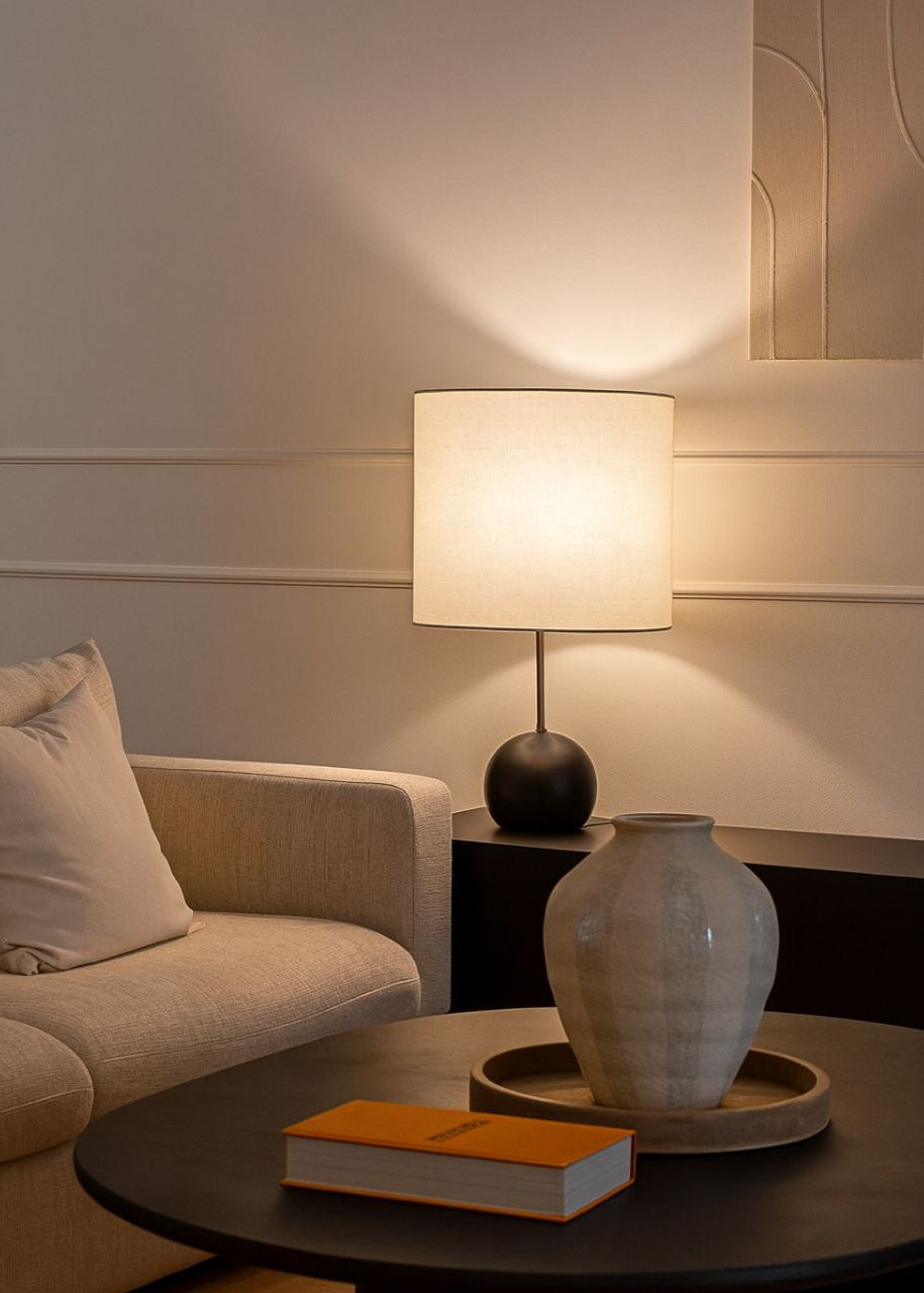 Lámpara de mesa de madera con pantalla beige.