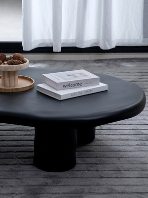 Detalle de mesa de centro ovalada con diseño irregular en color negro mate.