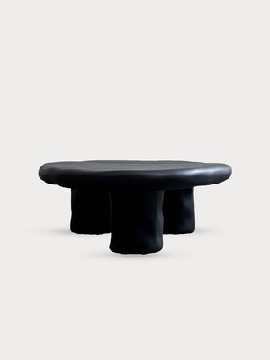 Mesa de centro ovalada con diseño irregular en color negro mate en vista lateral frontal.