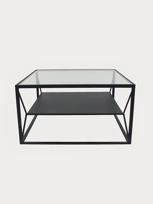 Mesa de acero en acabado negro con tablero de vidrio y un estante en el centro