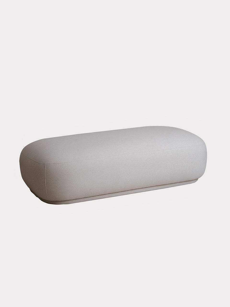 Puf en tejido beige alargado de estilo minimalista en vista frontal lateral.