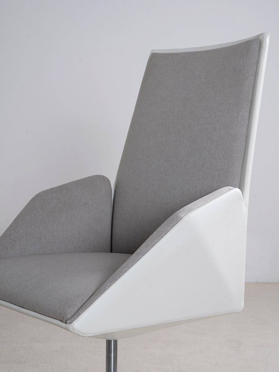 Detalle del asiento de la silla de escritorio en tejido gris y estructura blanca.