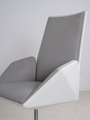 Detalle del asiento de la silla de escritorio en tejido gris y estructura blanca.
