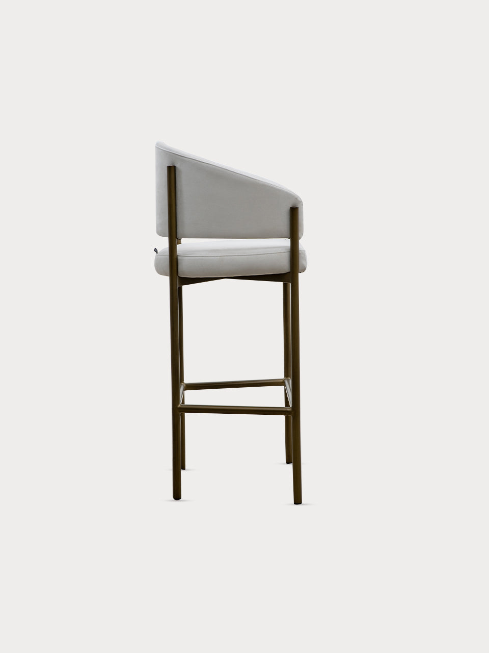 Taburete alto en tejido de tela de ante beige y patas metalizadas en vista lateral.
